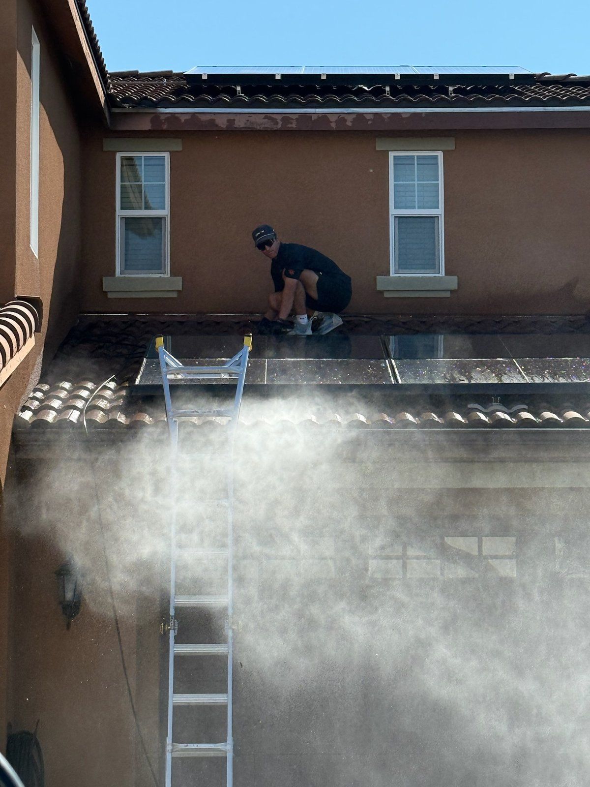 Lumon technician pressure washing a home exterior with a water spray