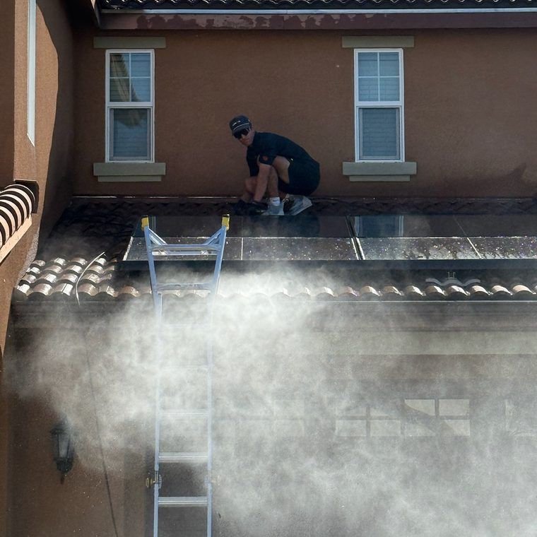Technician rinsing a home exterior