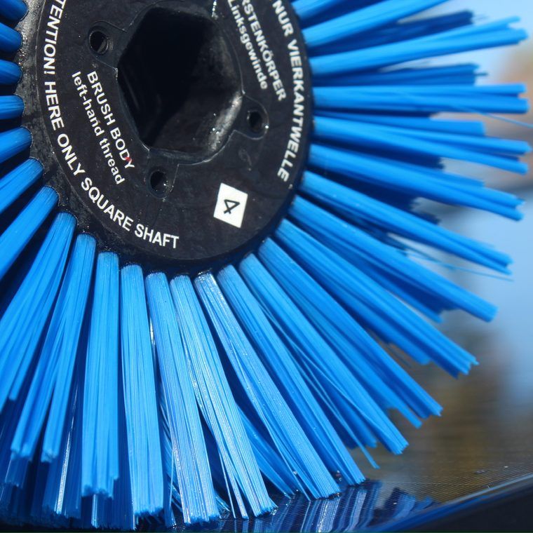 Close-up of a brush cleaning a solar panel