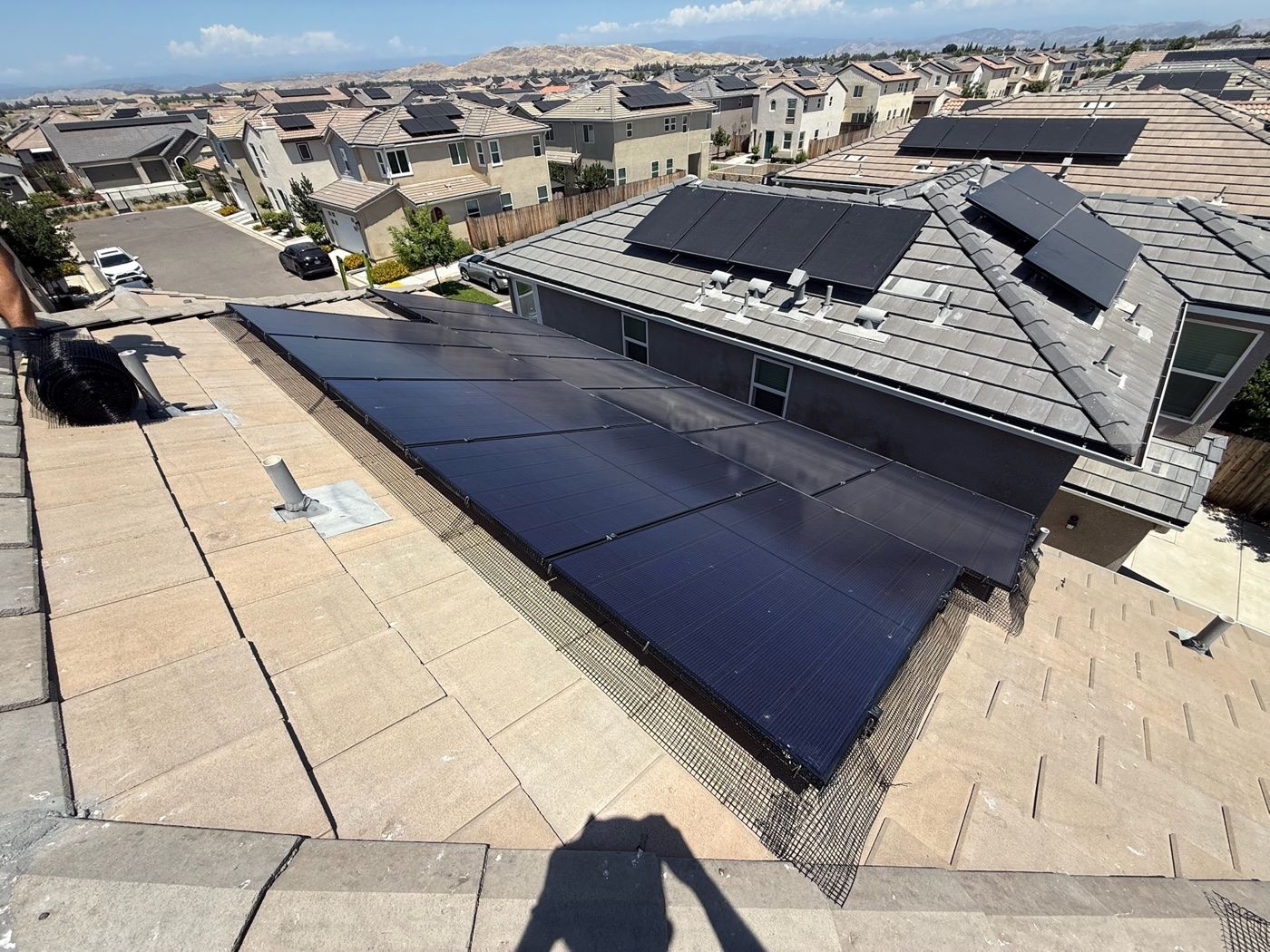 Mesh bird barrier installed along the edge of a rooftop solar array in Fresno