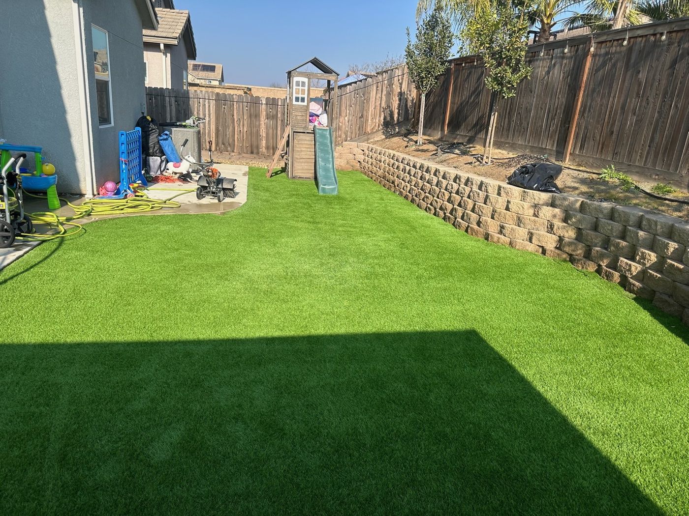 A fresh, green backyard artificial turf lawn